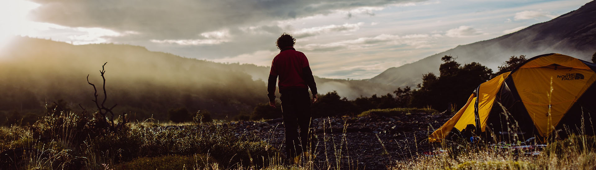 Trekker at a mountain camp at sunrise